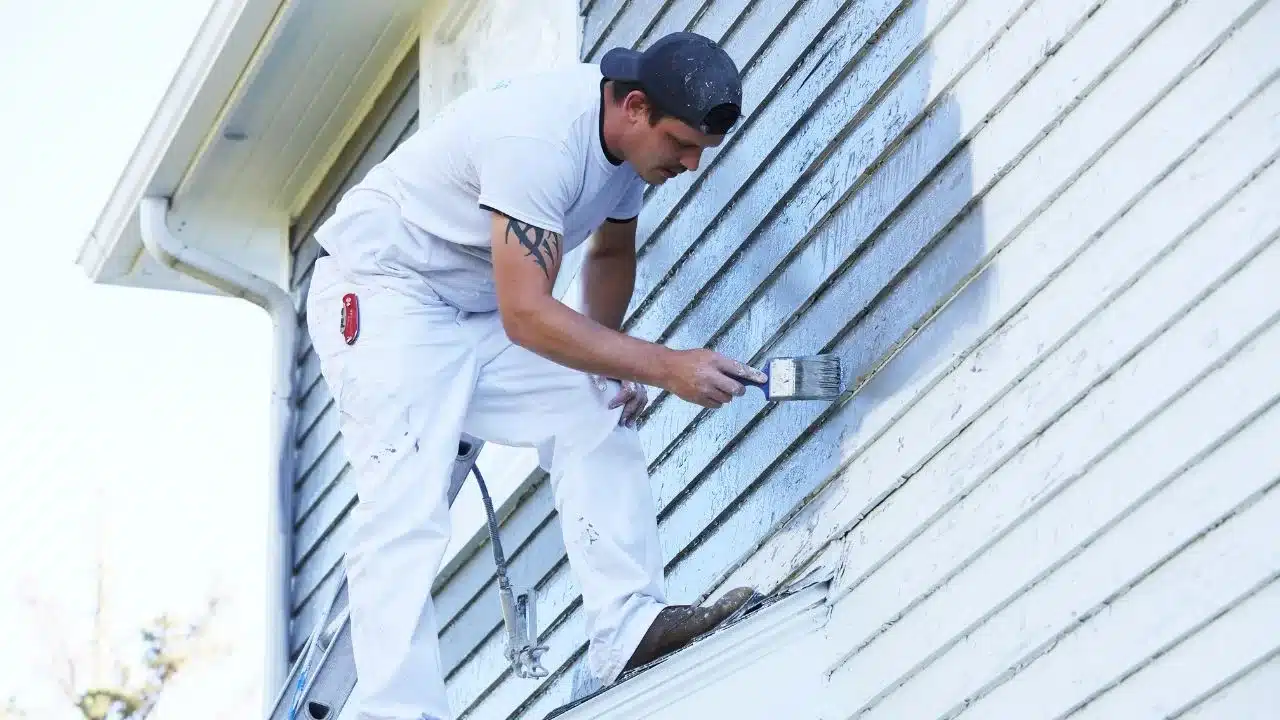 man doing exterior painting and repairs